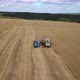 Aerial view: Flying above combine harvester unloading wheat in trailer - VideoHive Item for Sale
