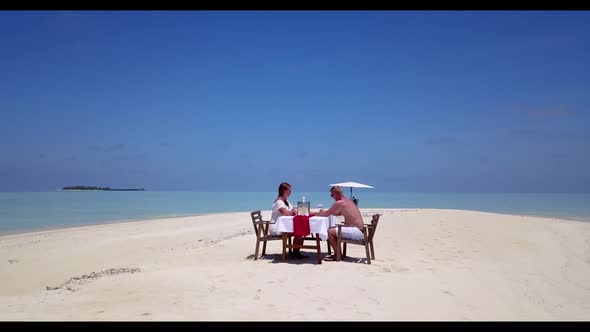 Young couple tanning on beautiful tourist beach holiday by clear water with white sand background of