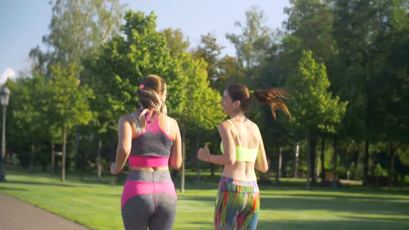 Beautiful Female Runners Jogging in Summer Park