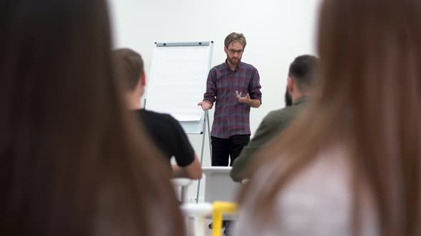 Bearded Businessman in Glasses Presenting New Project To Partners with Flip Chart, Team Leader