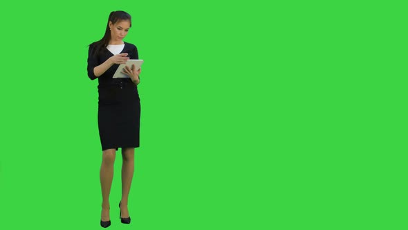 Concentrated Young Businesswoman Using Digital Tablet on a Green Screen, Chroma Key
