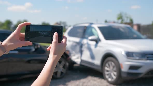 Stressed Driver Taking Picture on Sellphone Camera of Smashed Vehicle Calling for Emergency Service