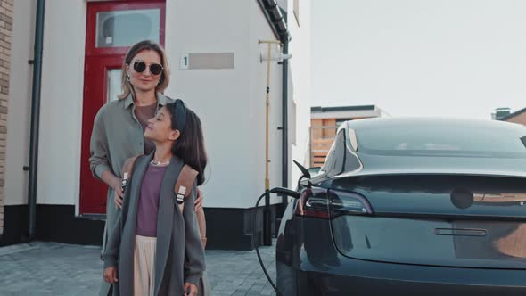 Portrait of Woman and Girl with Electric Car