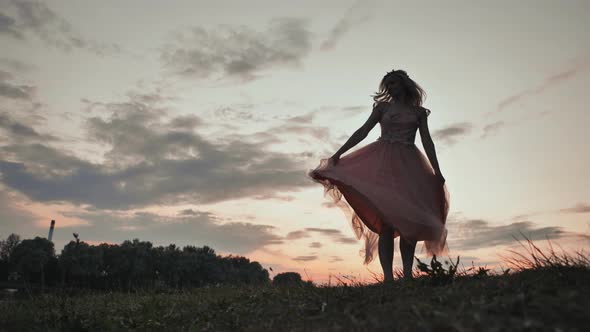 The Girl in the Dress Swirls Magically at Sunset