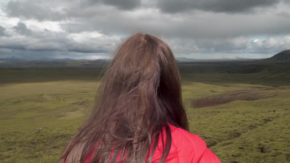 A Girl Looks at the Beautiful Landscape of Iceland.
