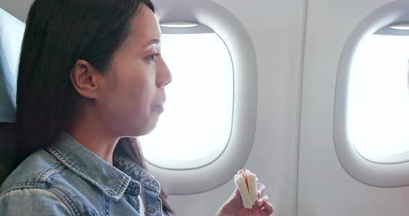 Woman eating sandwich on plane