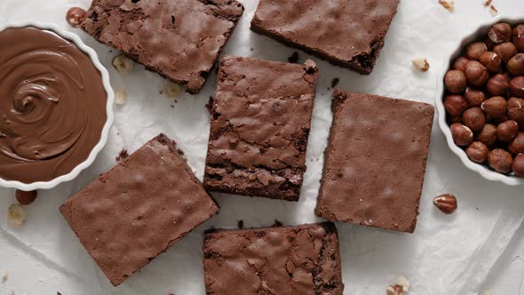 Fresh Homemade Chocolate Brownie Served with Hazelnuts and Melted Cream