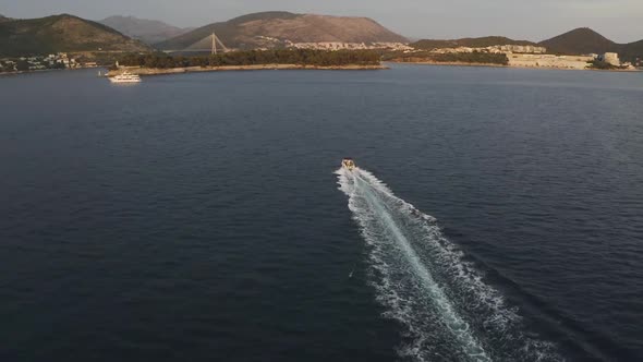 A speedboat speeds across the Adriatic sea near Dubrovnik, Croatia - Aerial