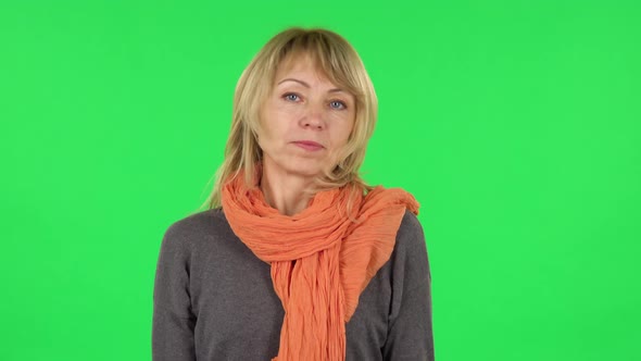 Portrait of Middle Aged Blonde Woman Is Shrugging and Sighing. Green Screen