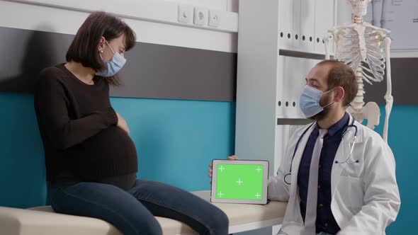 Doctor Holding Tablet with Horizontal Greenscreen at Checkup