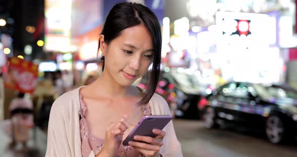 Woman use of cellphone online at night