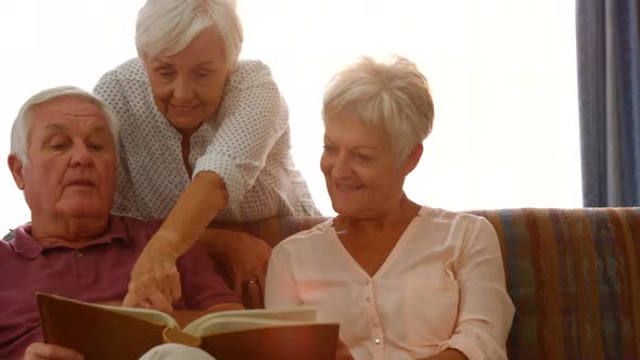 Happy senior friends reading a book