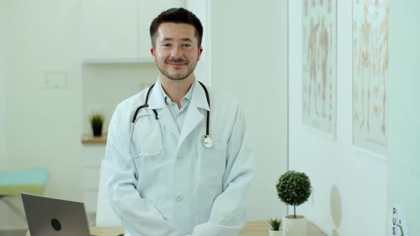 Smiling Young Man Professional Medic Doctor Wear White Medical Uniform Looking at Camera Standing in