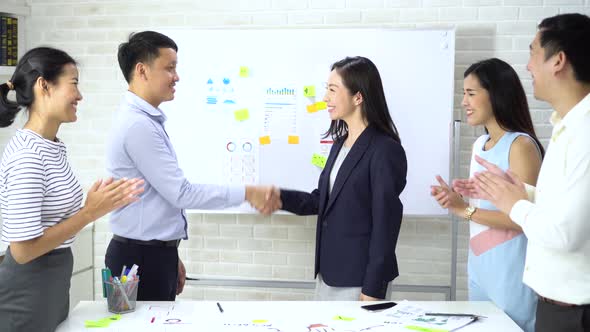 Young Business People Shaking Hands and Cheering Crowd Clapping Background