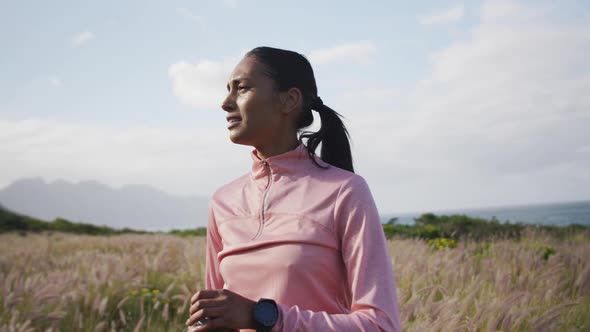 African american woman drinking water from bottle while hiking in the mountains