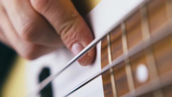 Bassist Finger Plays on Stainless Steel String of Guitar