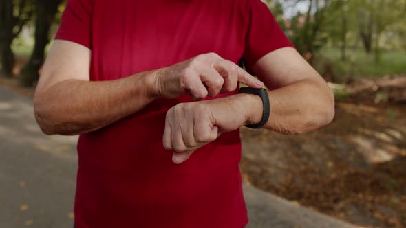 Senior Old Runner Man Starting Tapping Touchscreen on Smart Watch, Tracking Distance, Checking Pulse