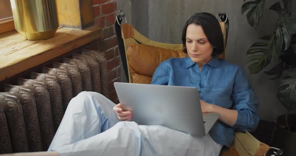 Close Up Attractive Hispanic Young Woman Smiling Sitting on Couch Looking at Laptop Screen