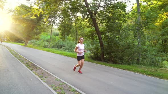 Young woman running in park on sunny day