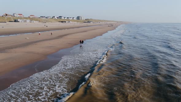 Drone Flies Over Ocean Beach in the City on a Summer Day