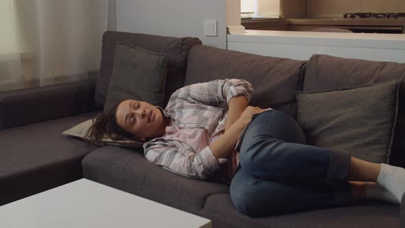 Adult Female Embracing Belly Suffering From Stomachache Indoors