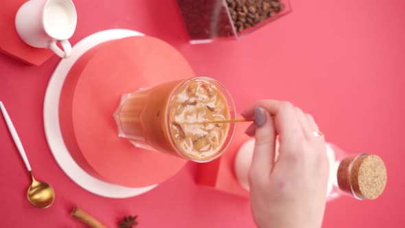 Vertical video: Stir ice latte in a glass