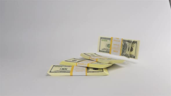 Bundles of Dollars Falling on White Surface