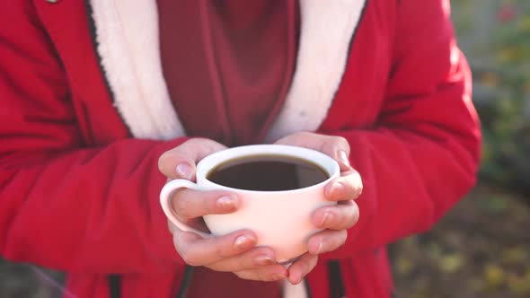 Close Up of Cup of Coffee in Woman's Hands