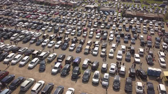 Aerial top view of many cars parked and people customers walking on car market or parking lot