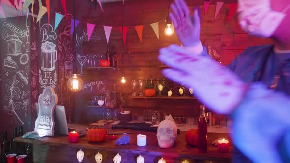 A Bar Decorated for Halloween and Young People in Scary Outfits Are Dancing