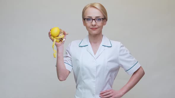 Nutritionist Doctor Healthy Lifestyle Concept - Holding Ginger Root, Lemon Fruit and Measuring Tape