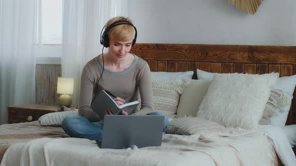 Smiling Beautiful Woman in Headphones Stay at Home During Quarantine Looking at Laptop Screen Use