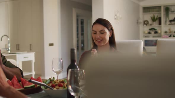 Smiling caucasian mother sitting at table in prayer before family meal