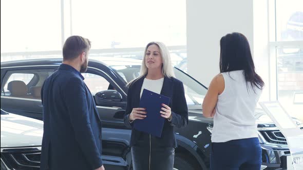 Young Beautiful Car Salesman Explains Something To Its Customers