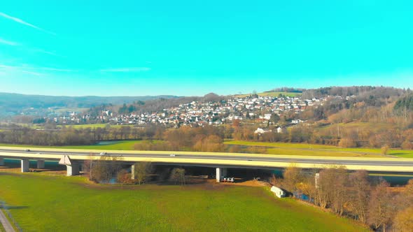 drone flight over a highway bridge with cars and trucks panorama view