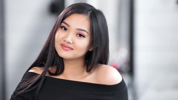 Medium Closeup Portrait of Beautiful Young Asian Girl Smiling and Looking at Camera