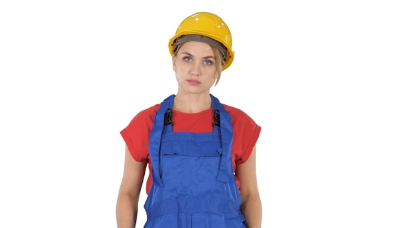 Young construction woman in hardhat walking on white background.