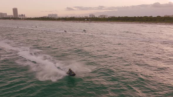 Jet skis competition running on sea along Miami Beach coast, Florida. Aerial sideways ascending slow