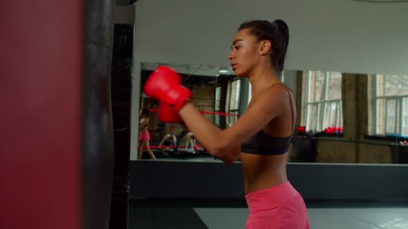 Breathless Exhausted Black Woman Fighter Resting on Punching Bag After Training