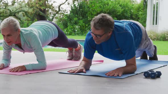 Senior couple exercising in a garden