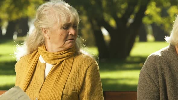 Elderly Friends Sitting Apart After Conflict, Prying Information in Newspaper