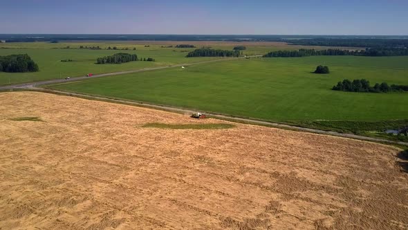 Combine Harvester Stands on Ripe Crop Field Near Highway