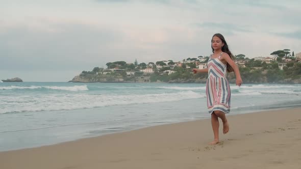 Cheerful Girl Dancing at Coastline