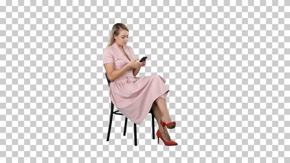 Young Woman with blond hair sitting on a chair reading texting