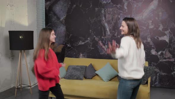 Cheerful Mother and Daughter Dancing to Favourite Song Together