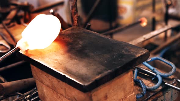 Glassblower shaping a molten glass