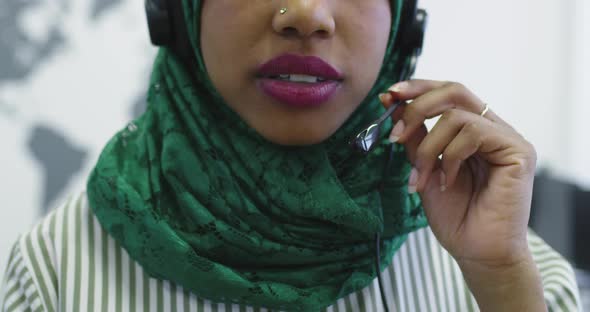 African Islamic Businesswoman with Hijab Wearing a Headset While Standing in the Modern Office