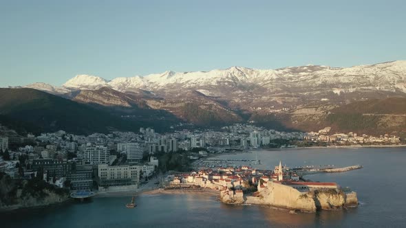 Aerial View of winter Budva, the old town in Montenegro and snow-capped mountains