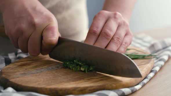 Close up of hands of woman cutting chives at the kitchen. Shot with RED helium camera in 4K.