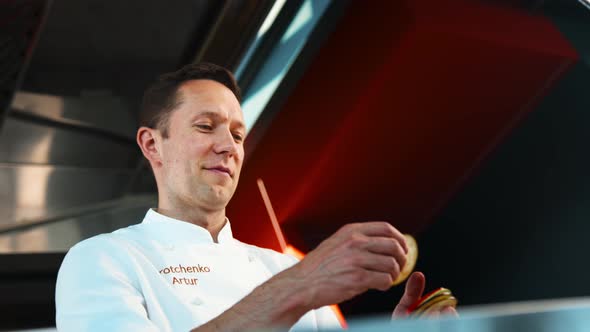 Close-up: Chef smiles and laughs while working. The process of preparing food with a restaurant.ant.